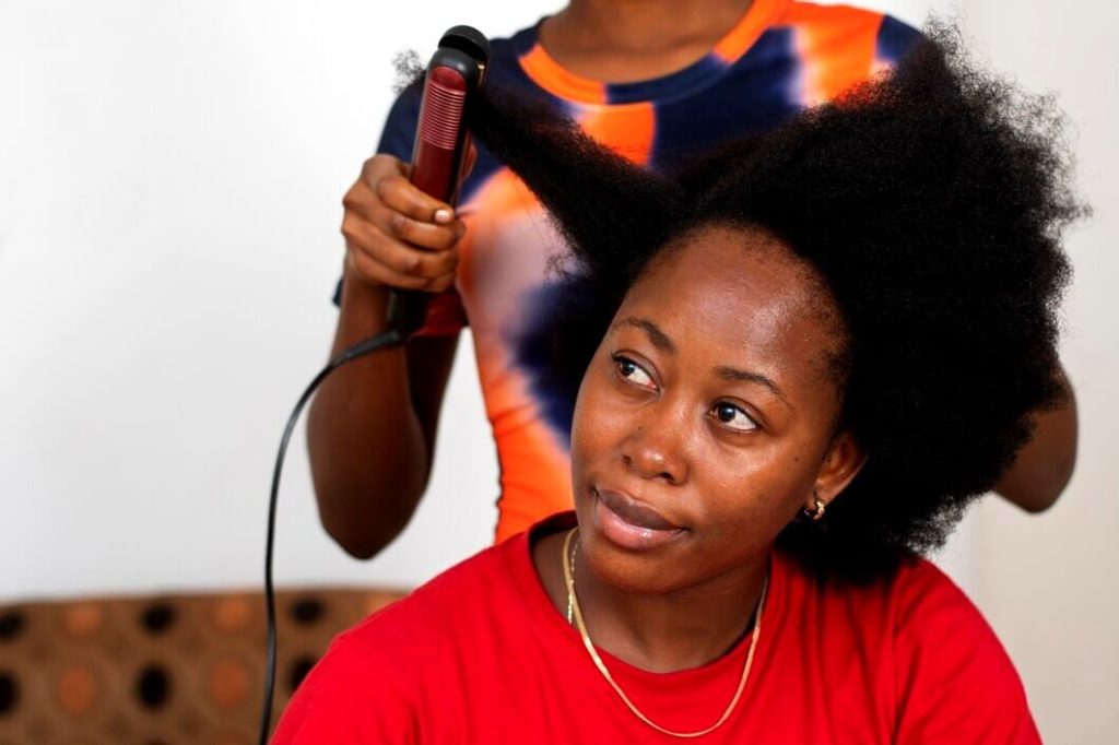 Femme noire fais un défrisage de cheveux