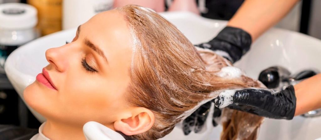belle-jeune-femme-caucasienne-recevant-se-laver-cheveux-dans-salon-coiffure