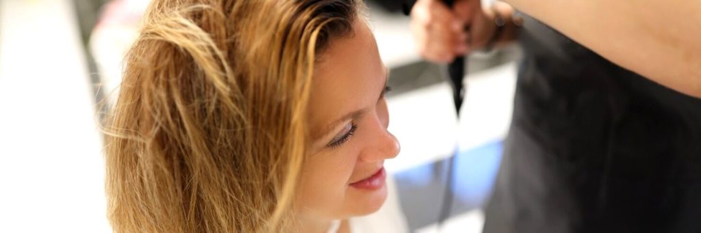 coiffeur-sechant-cheveux-seche-cheveux-cliente-dans-salon-beaute